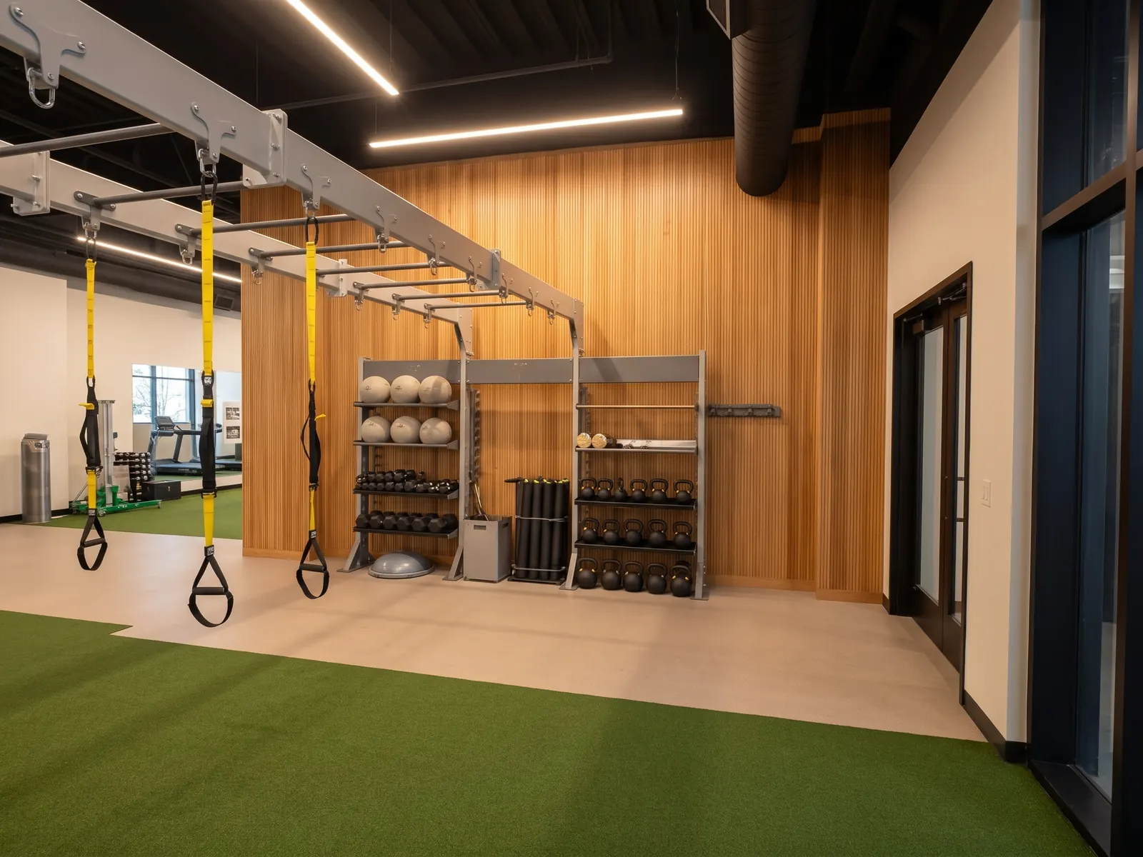 Custom decorative vertical wood slat wall paneling installed by California Woodworking for a commercial gym in Los Angeles CA